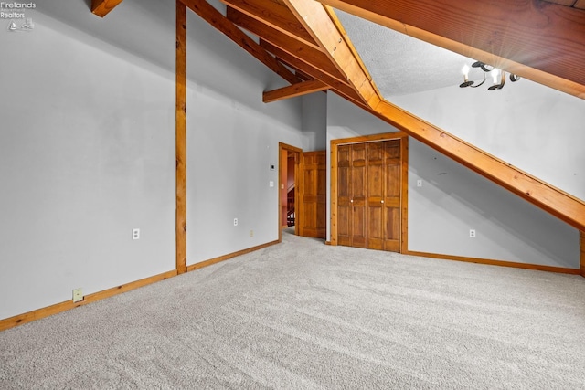 additional living space with carpet and lofted ceiling with beams