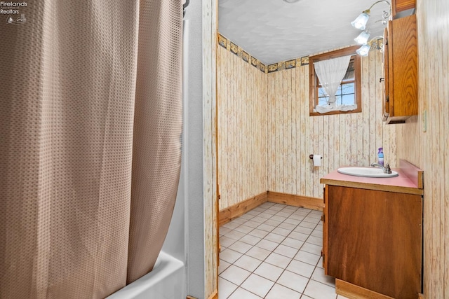 bathroom with tile patterned floors, vanity, shower / bath combo, and wooden walls