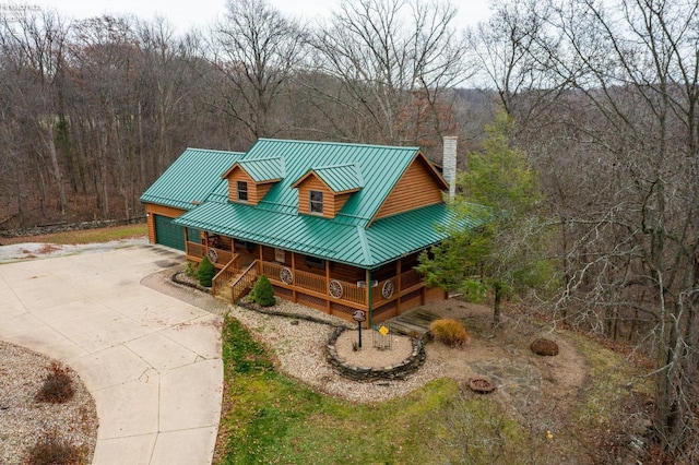 log cabin featuring covered porch and a garage