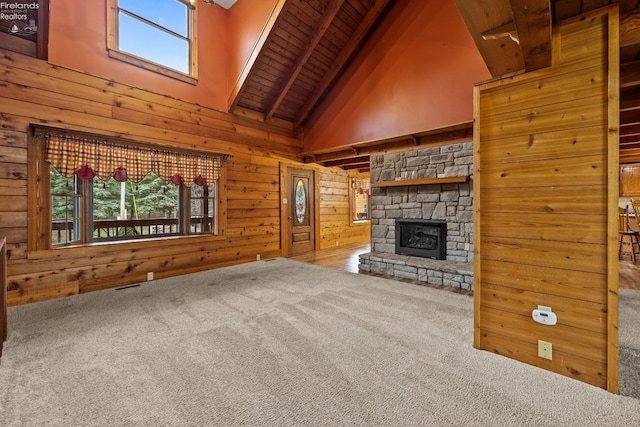 unfurnished living room featuring beam ceiling, carpet floors, high vaulted ceiling, and a healthy amount of sunlight