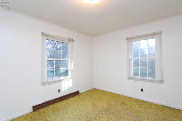 carpeted empty room featuring baseboard heating and ornamental molding