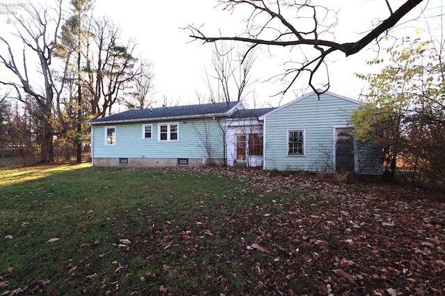 rear view of property featuring a lawn