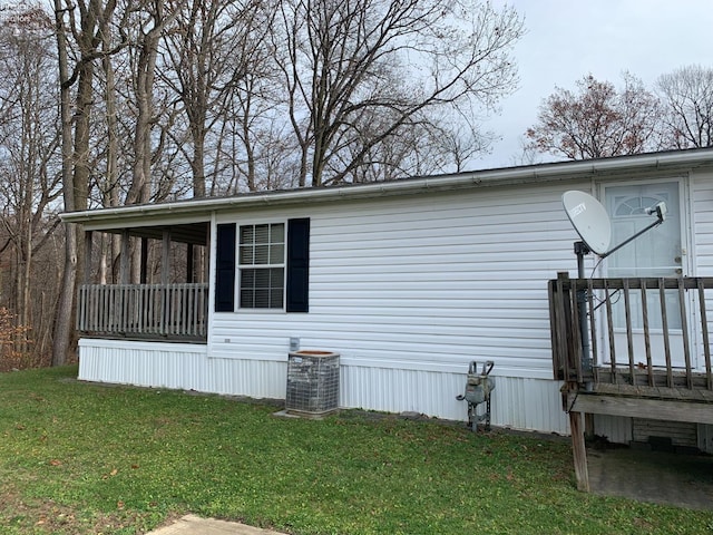 view of home's exterior featuring central AC unit and a lawn