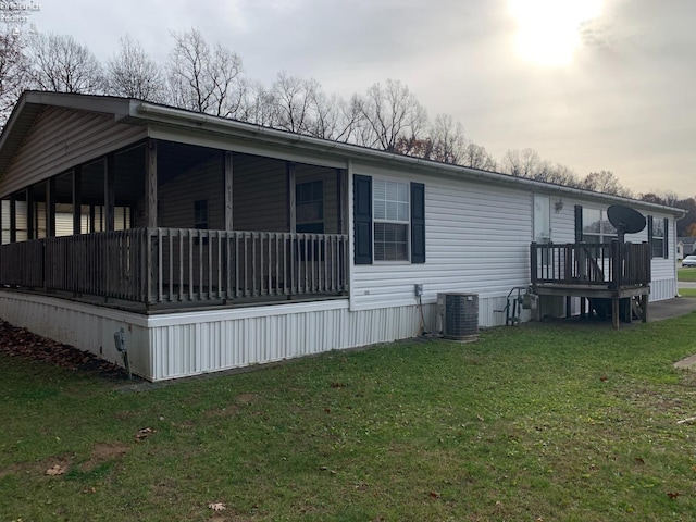 view of home's exterior featuring a lawn and central AC