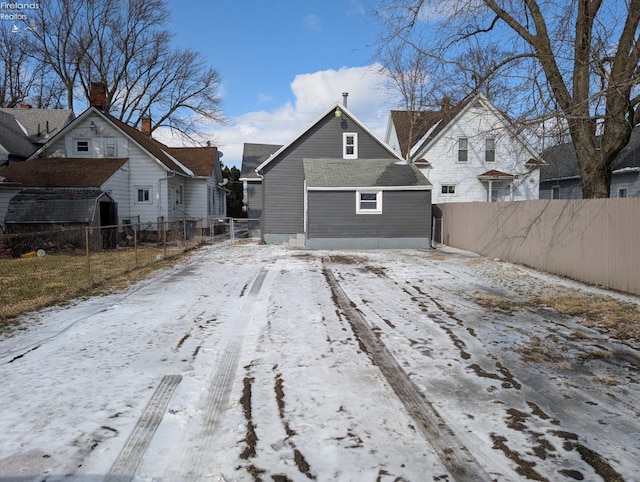 view of snow covered back of property