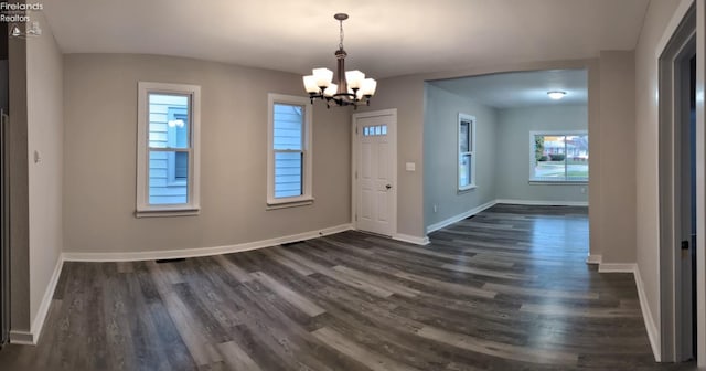 foyer featuring dark wood-type flooring and a chandelier