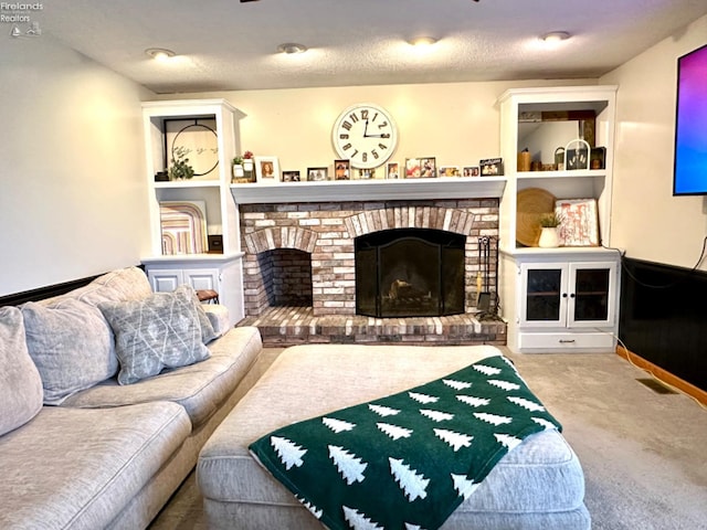 living room featuring carpet, a textured ceiling, and a brick fireplace