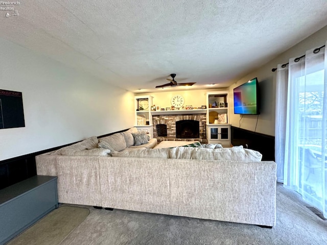 living room featuring a fireplace, carpet, and a textured ceiling