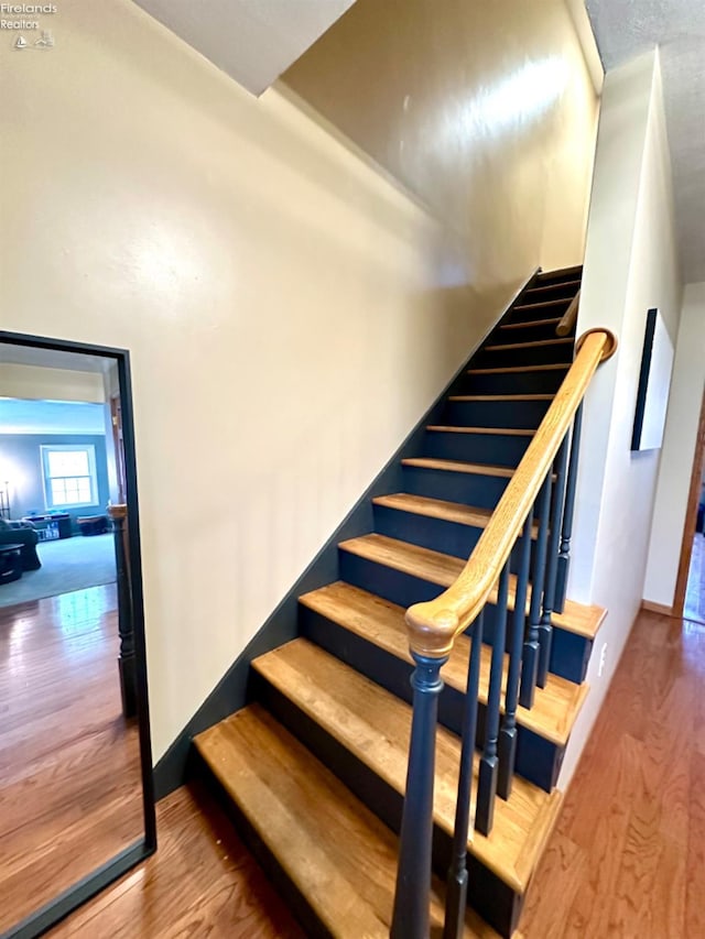 stairs featuring hardwood / wood-style flooring