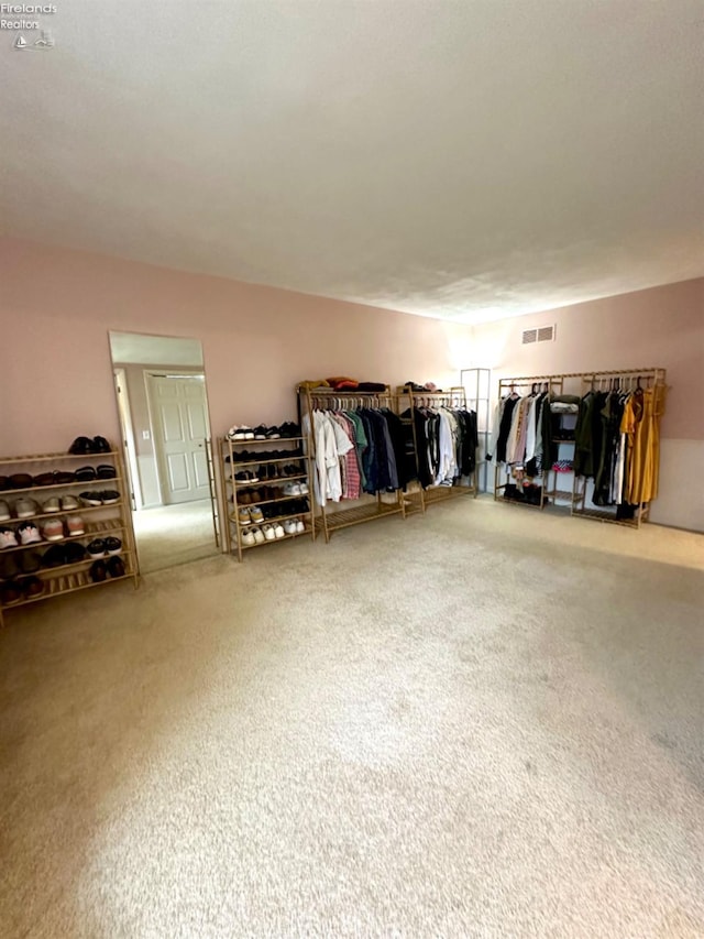 walk in closet with carpet