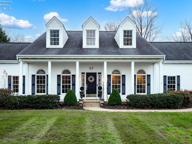 cape cod house with covered porch and a front yard