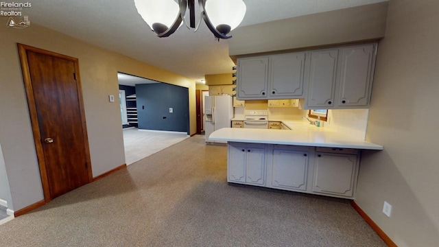 kitchen featuring white appliances, kitchen peninsula, a notable chandelier, light colored carpet, and white cabinetry