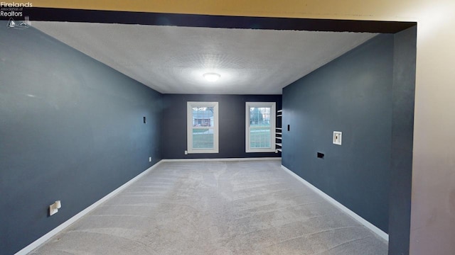 spare room featuring carpet floors and a textured ceiling