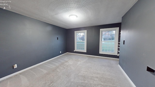 unfurnished room featuring carpet floors and a textured ceiling