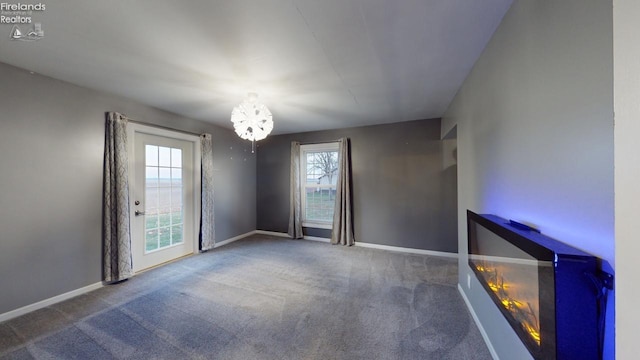 spare room with carpet flooring and a chandelier