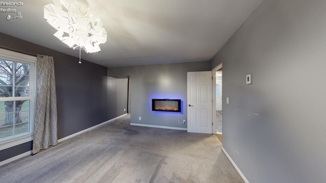 unfurnished living room with carpet flooring and a notable chandelier