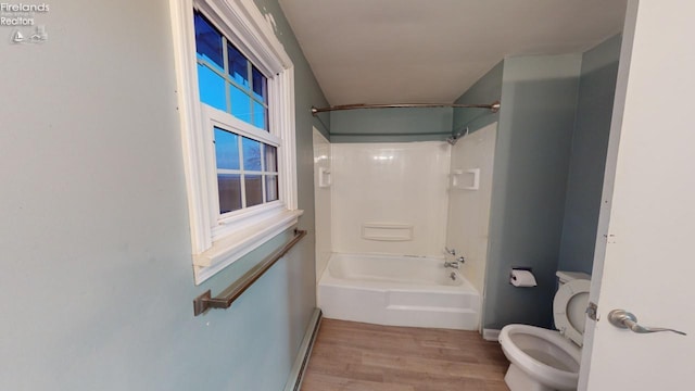 bathroom with hardwood / wood-style floors, toilet, and tub / shower combination