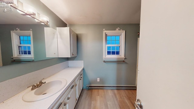 bathroom featuring wood-type flooring, vanity, and baseboard heating