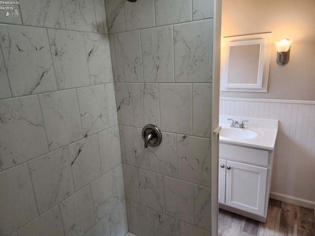 bathroom featuring hardwood / wood-style floors, vanity, and tiled shower