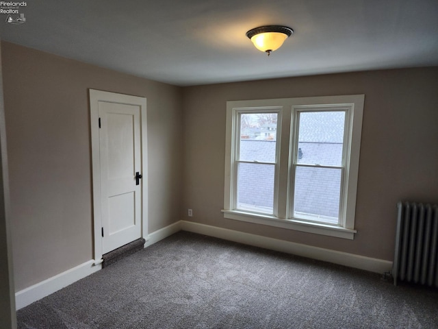 carpeted spare room with radiator heating unit