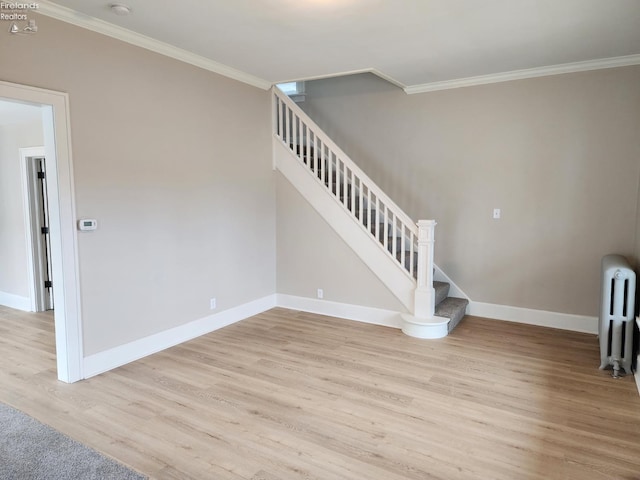 interior space featuring hardwood / wood-style flooring, ornamental molding, and radiator