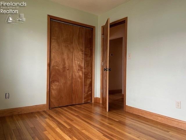 unfurnished bedroom with light hardwood / wood-style flooring and a closet