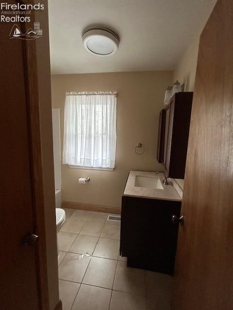 bathroom with tile patterned flooring, vanity, and toilet