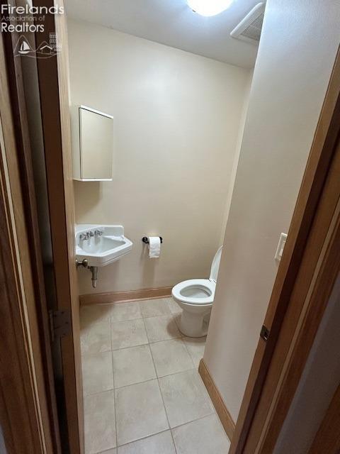 bathroom featuring tile patterned floors, toilet, and sink