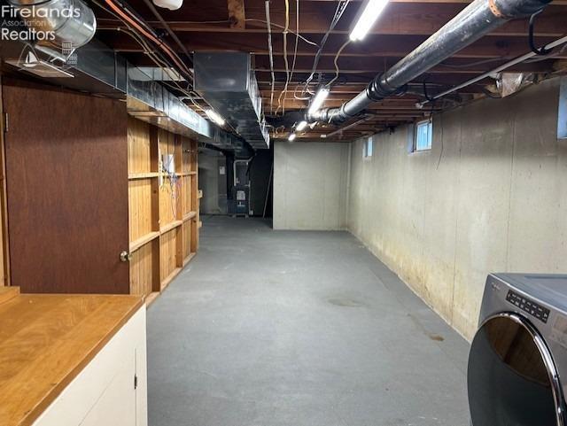 basement featuring heating unit and washer / dryer