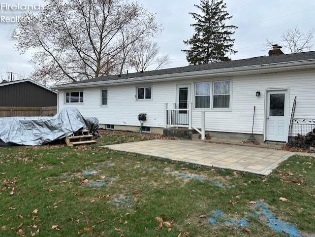 back of property featuring a patio area and a yard