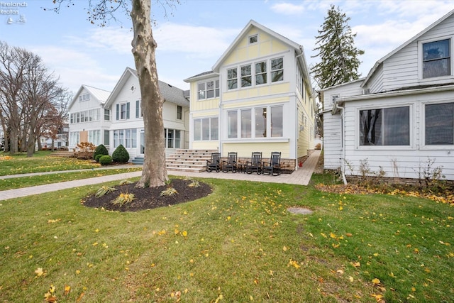 rear view of house featuring a yard and a patio