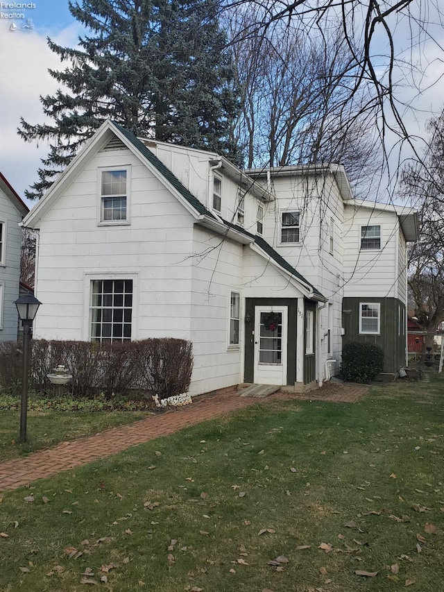 rear view of house featuring a yard