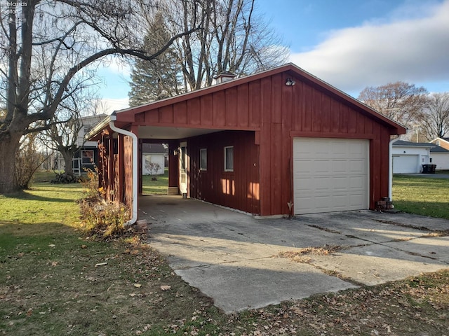 garage featuring a carport and a lawn