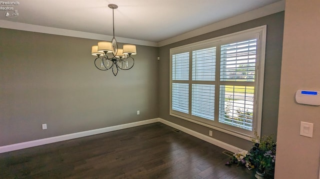 unfurnished room with dark hardwood / wood-style flooring, crown molding, and a chandelier