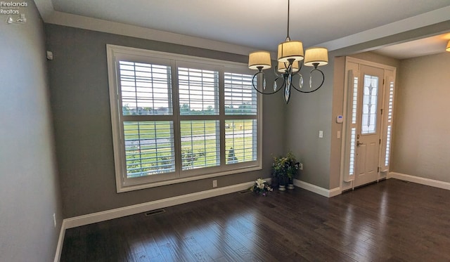 entryway featuring a notable chandelier, plenty of natural light, and dark wood-type flooring