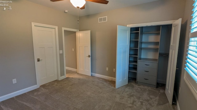 unfurnished bedroom with dark colored carpet, ceiling fan, and a closet