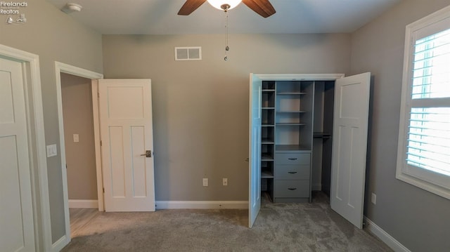 unfurnished bedroom with ceiling fan, carpet floors, and a closet