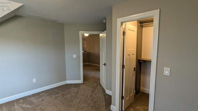 hall featuring dark colored carpet