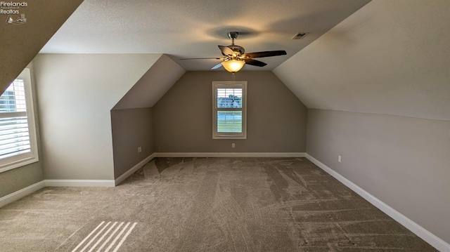 bonus room with carpet flooring, a textured ceiling, vaulted ceiling, and ceiling fan