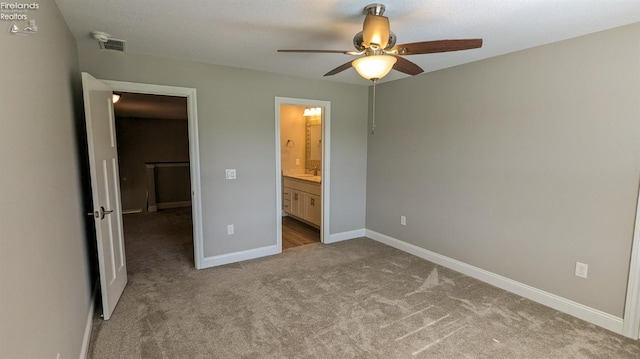 unfurnished bedroom with ensuite bath, ceiling fan, and light carpet