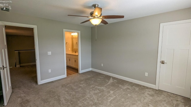 unfurnished bedroom with light carpet, ceiling fan, and ensuite bathroom