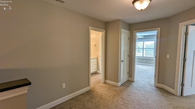 corridor featuring light colored carpet