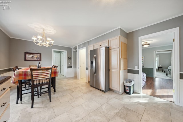 dining area with light hardwood / wood-style floors, ornamental molding, and a chandelier