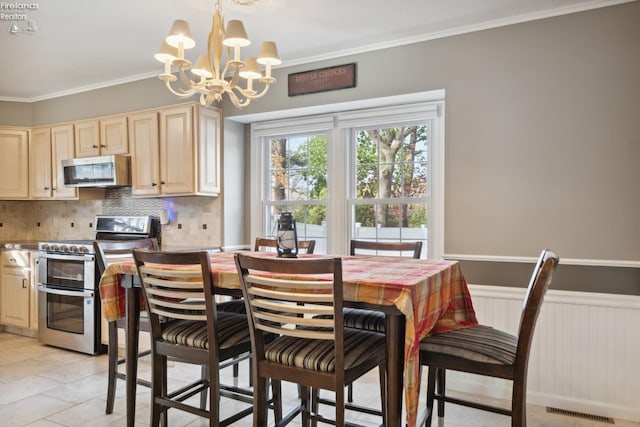 kitchen featuring stainless steel appliances, backsplash, a chandelier, decorative light fixtures, and ornamental molding