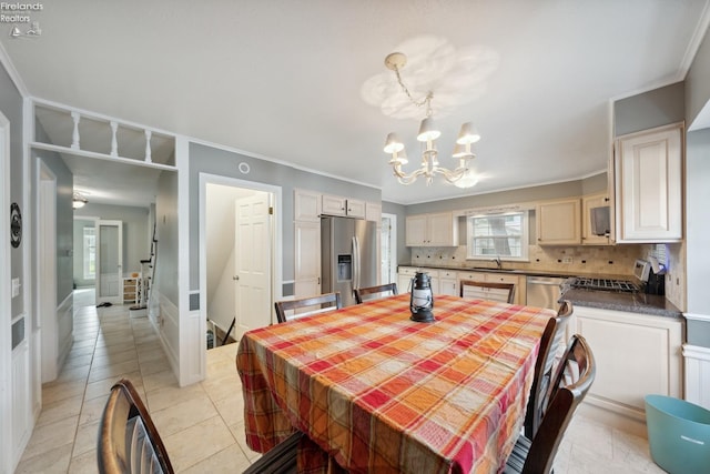 dining space with light tile patterned floors, crown molding, a notable chandelier, and sink