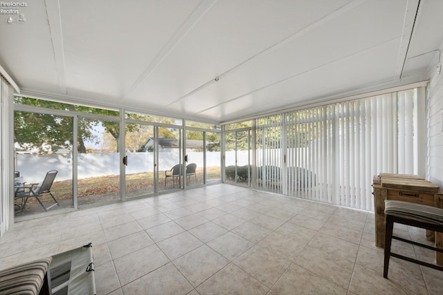 sunroom featuring a water view