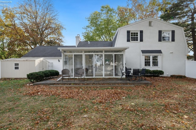 back of property featuring a sunroom, a patio area, and a storage shed