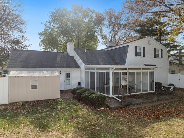 rear view of property with a sunroom and a yard