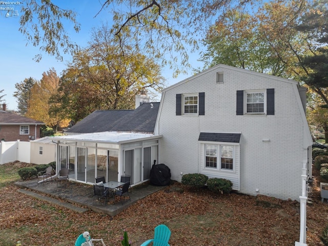 rear view of house featuring a patio area and a sunroom