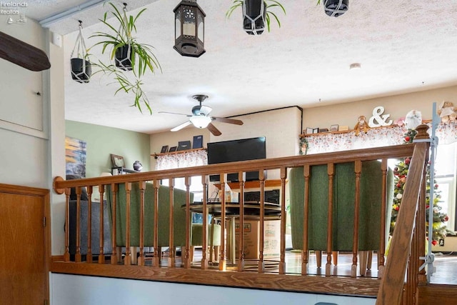 stairs featuring ceiling fan and a textured ceiling